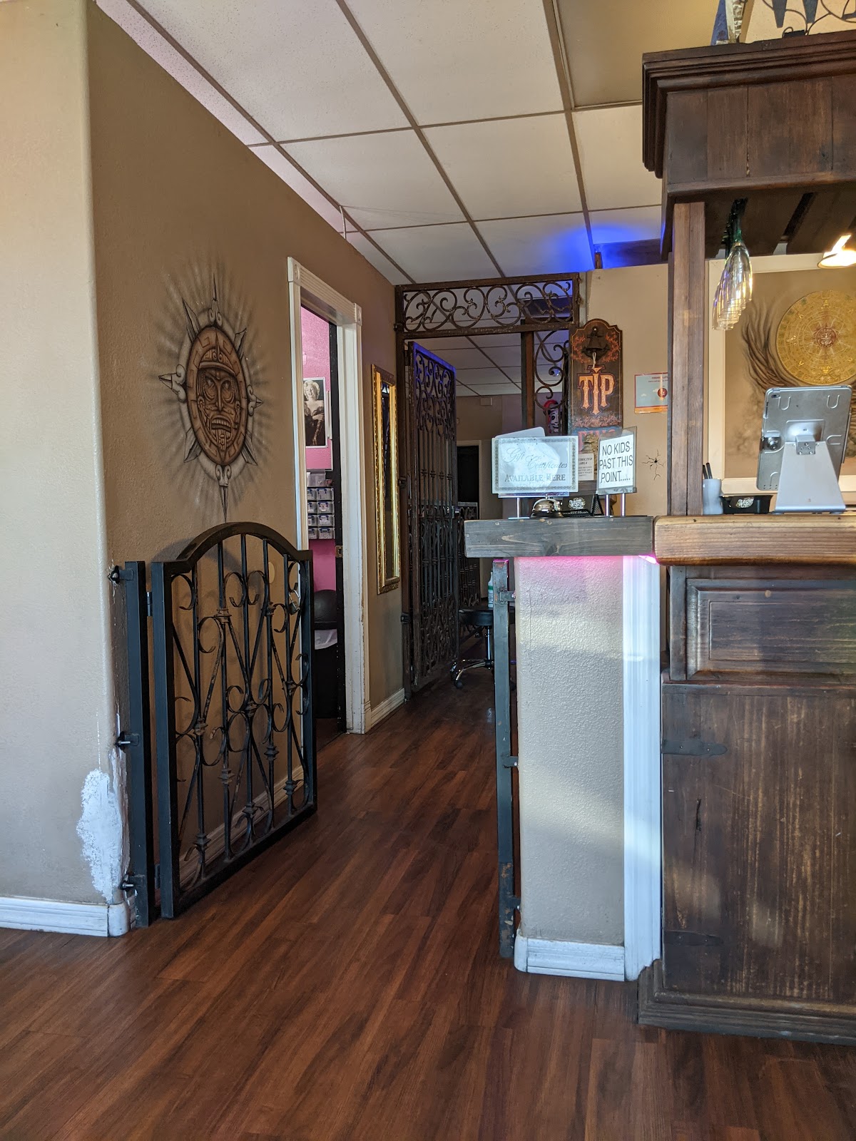 Wrought iron gates inside the shop near the front desk, with the tip bell and gift certificate sign.